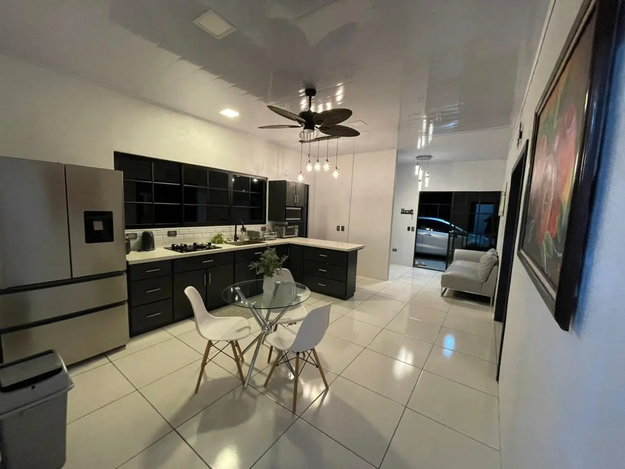 Cocina interior moderna con muebles oscuros y mesones blancos en casa construida en San Carlos