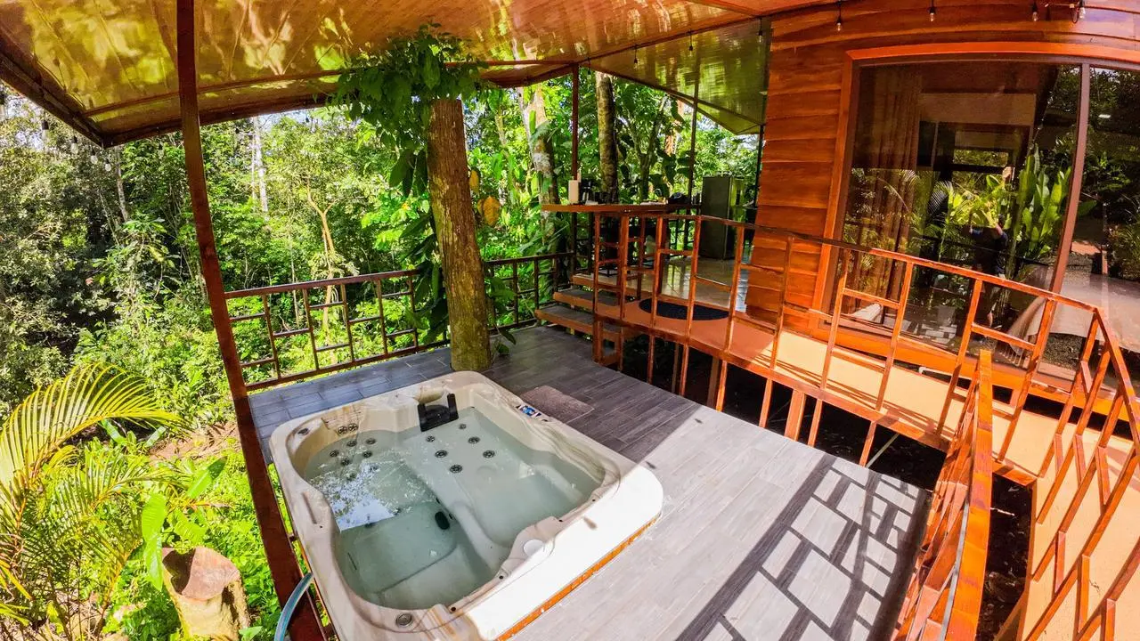 Jacuzzi privado en terraza de madera con vista a la selva del Arenal en La Fortuna